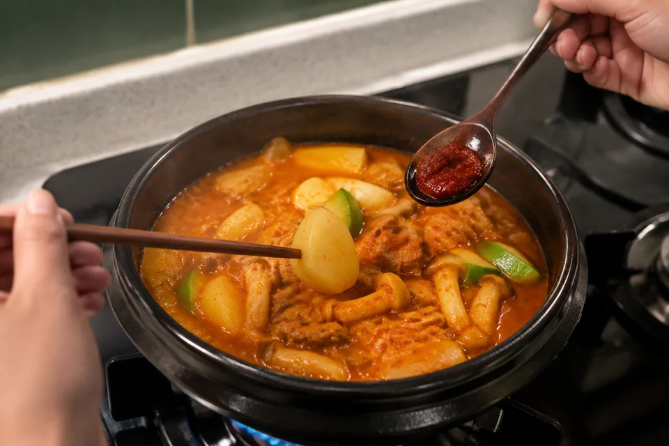 돼지고기 고추장찌개의 감자를 젓가락으로 찔러 익힘을 확인하는 모습
